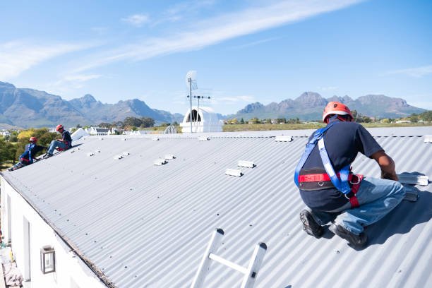 A team of workers install brackets for solar panels on the roof of a house.